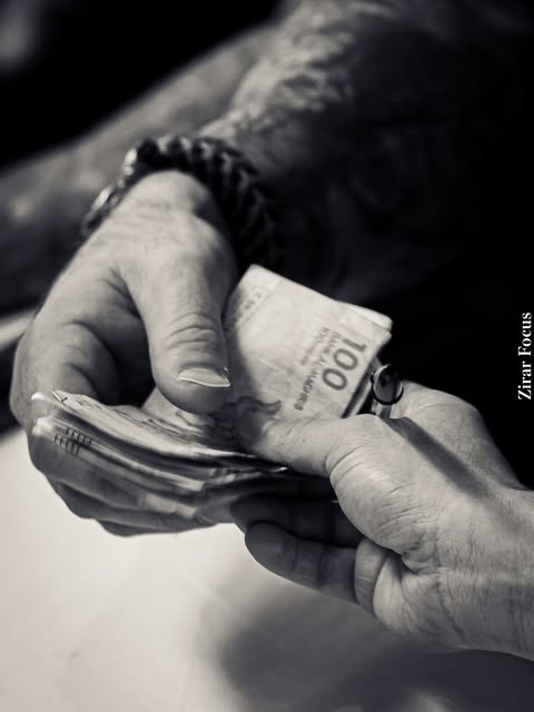 Gros plan en noir et blanc de mains tenant des billets